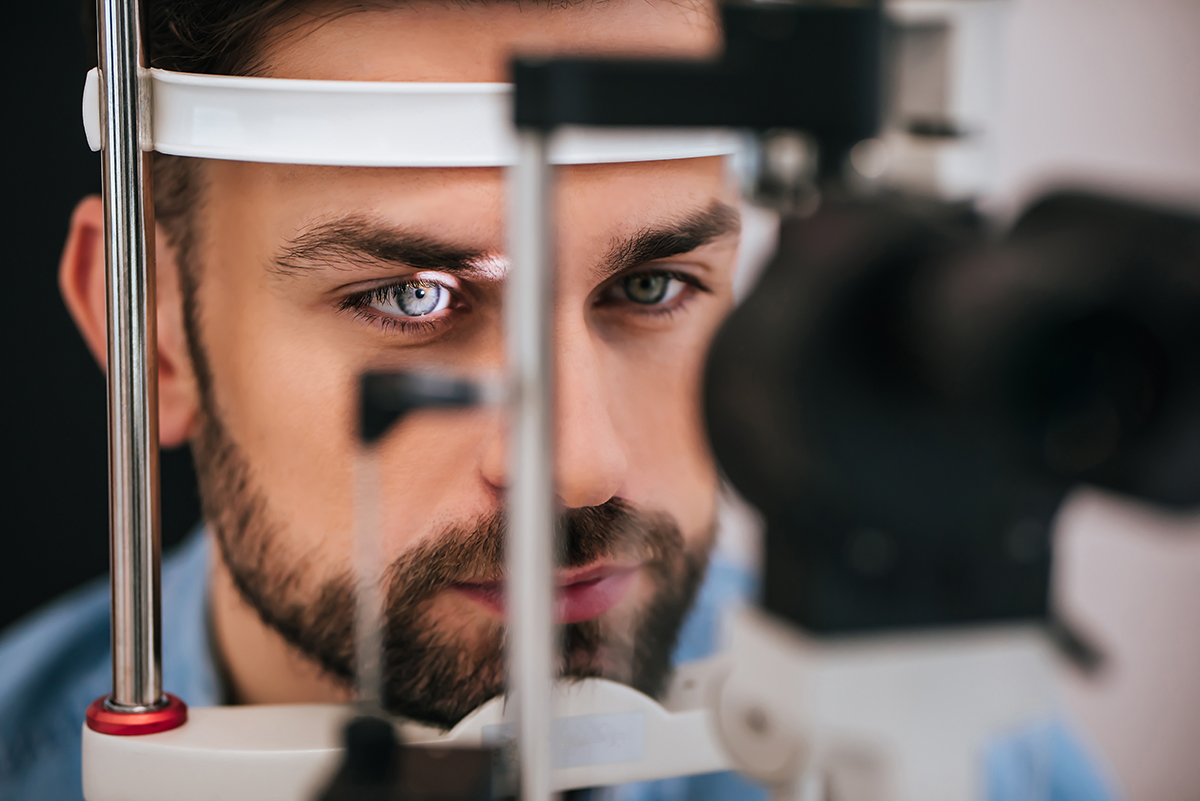Handsome young man is checking the eye vision in modern ophthalmology clinic. Patient in ophthalmology clinic